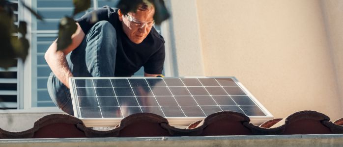 A person holding a solar panel and looking at it